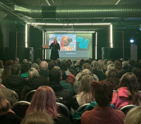 Lucy speaking in front of audience